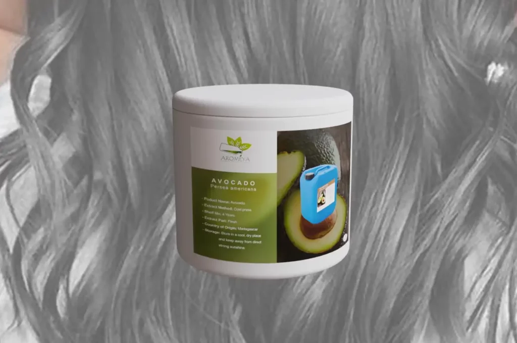 Bottle of avocado oil placed in front of long, straight wavy hair, highlighting its nourishing benefits for hair care