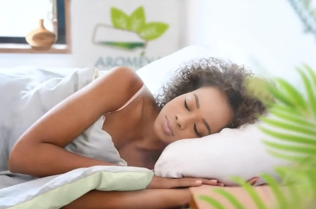 A peaceful girl sleeping beside an essential oil diffuser emitting a gentle mist in a calm, softly lit room